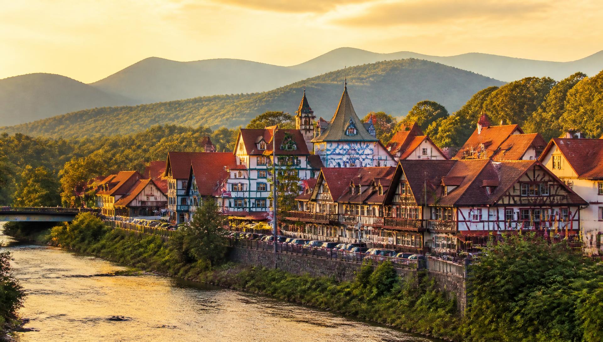 The Bavarian village of Helen, Georgia along the Chattahoochee River at golden hour with the Blue Ridge mountains behind
